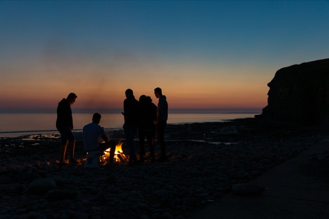 Des silhouettes autour d'un feu de camp